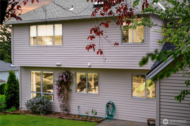 back of property featuring roof with shingles