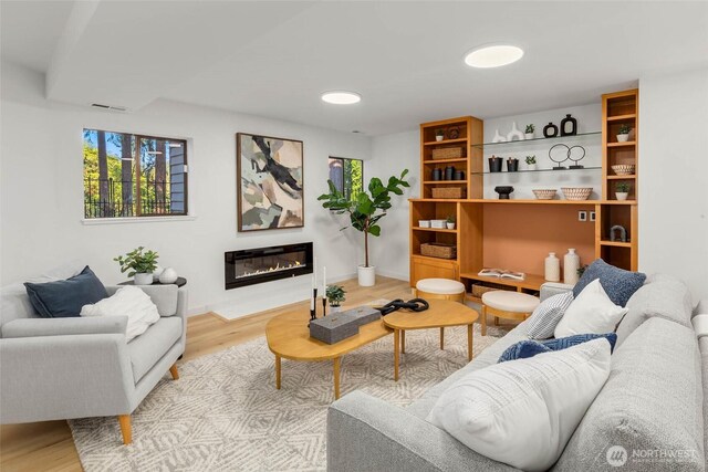 11324 83rd Pl NE, Kirkland, WA 98034 - living area with a glass covered fireplace, wood finished floors, visible vents, and baseboards