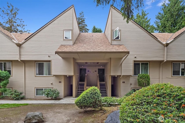 multi unit property featuring stairway and roof with shingles
