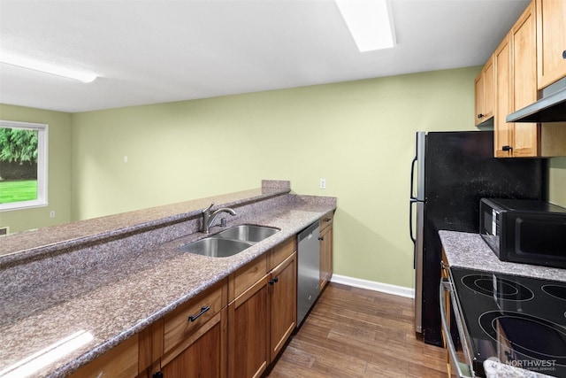 kitchen featuring dark wood-style flooring, black microwave, baseboards, a sink, and dishwasher