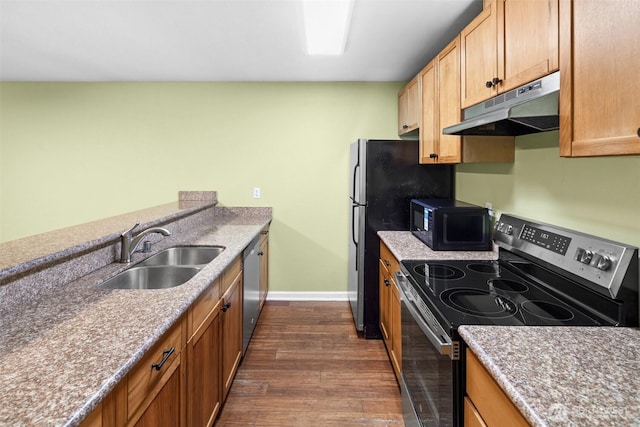 kitchen with baseboards, dark wood-style floors, under cabinet range hood, a sink, and appliances with stainless steel finishes