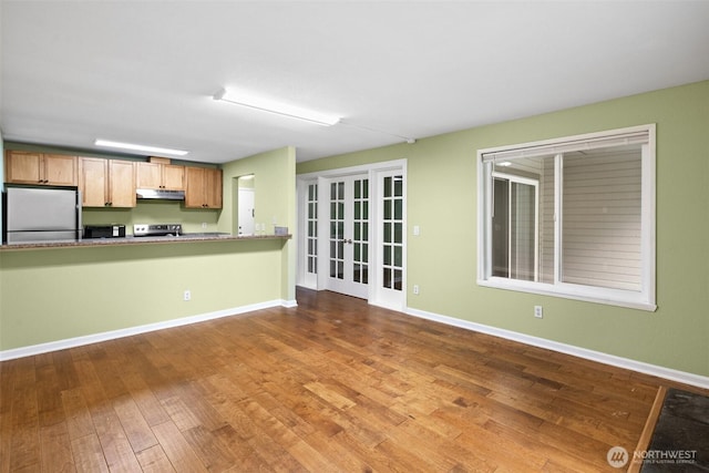 interior space with french doors, baseboards, and wood finished floors