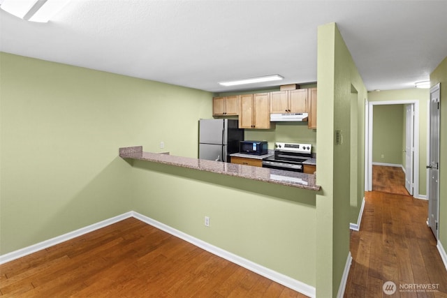 kitchen with dark wood-type flooring, baseboards, appliances with stainless steel finishes, and under cabinet range hood
