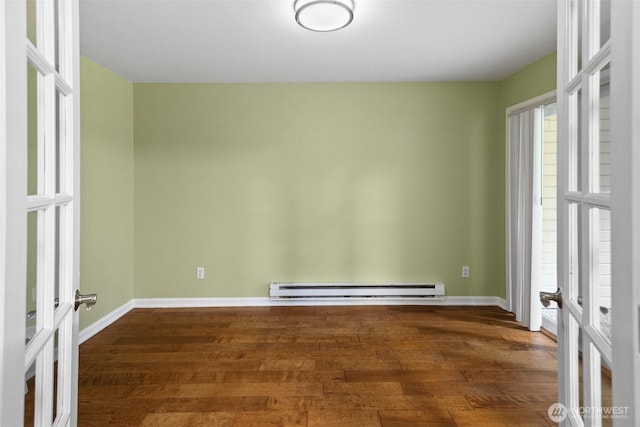 unfurnished room featuring french doors, a baseboard heating unit, a wealth of natural light, and wood finished floors