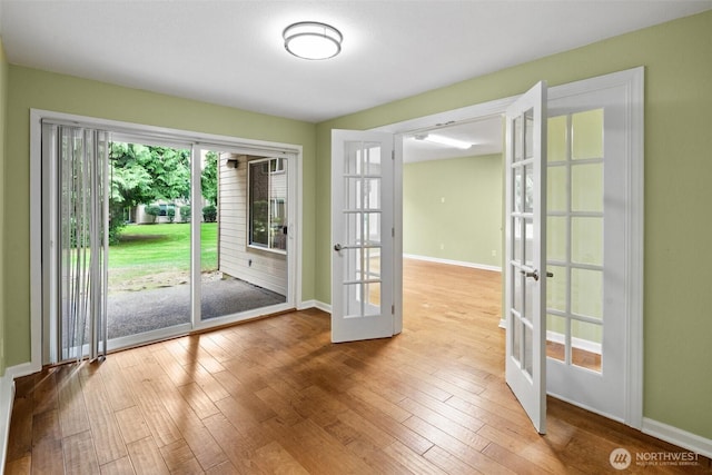 doorway with baseboards, french doors, and hardwood / wood-style flooring