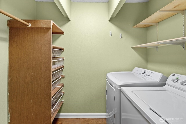 clothes washing area featuring laundry area, baseboards, and separate washer and dryer