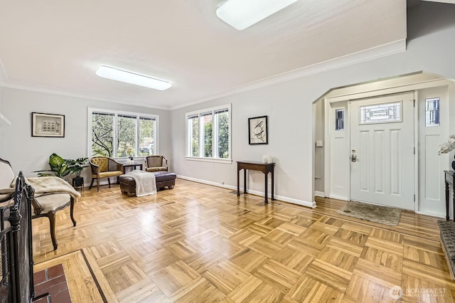 foyer entrance with crown molding, arched walkways, and baseboards