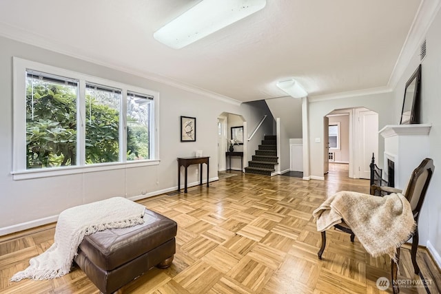 living room featuring arched walkways, baseboards, and stairway