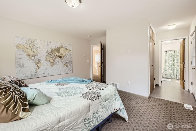 carpeted bedroom featuring baseboards and visible vents
