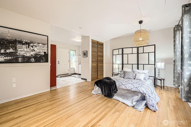 bedroom with baseboards, a closet, and wood finished floors