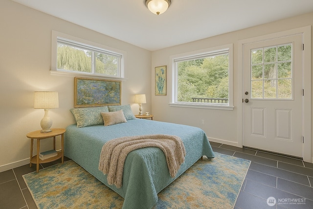 bedroom featuring dark tile patterned floors and baseboards