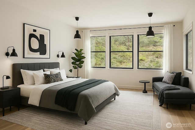 bedroom with multiple windows and light wood finished floors