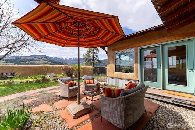 view of patio / terrace with fence, a mountain view, and an outdoor hangout area