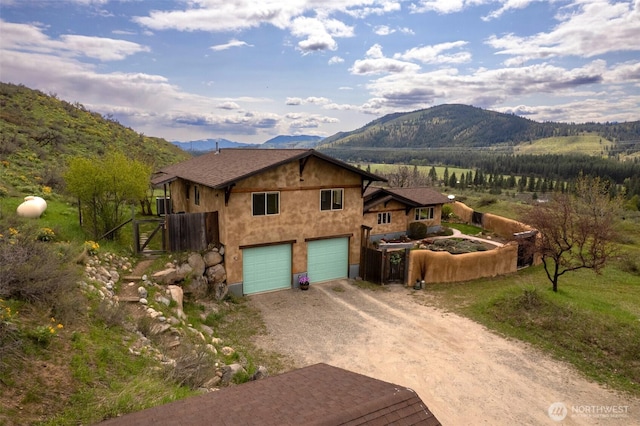 view of home's exterior featuring driveway, a mountain view, and a garage