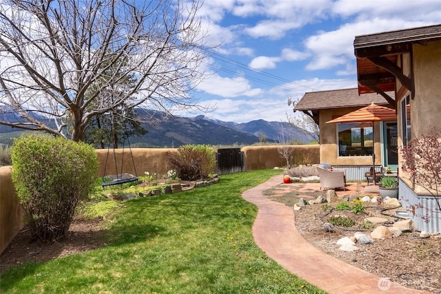 view of yard featuring fence and a mountain view