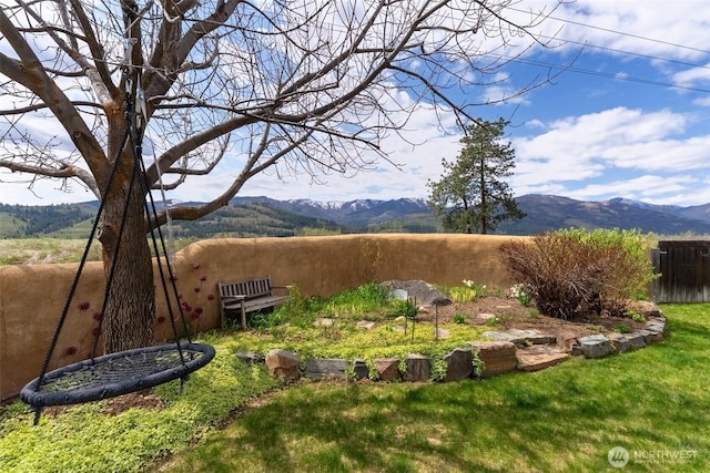 view of yard with fence and a mountain view