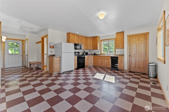 kitchen with visible vents, baseboards, light countertops, dark floors, and black appliances