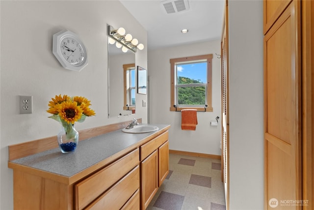 bathroom featuring tile patterned floors, visible vents, baseboards, and vanity