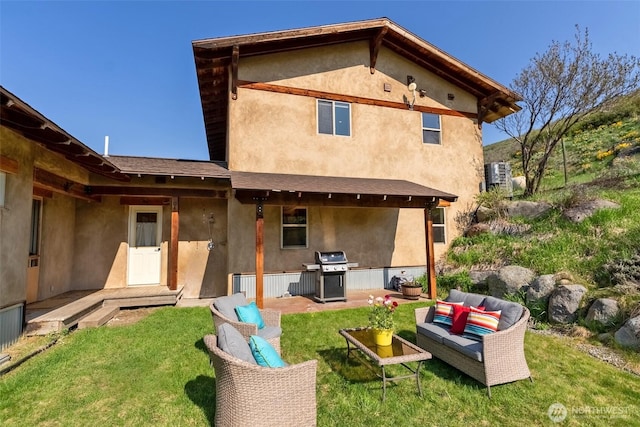 back of property featuring a yard, an outdoor hangout area, a patio area, and stucco siding