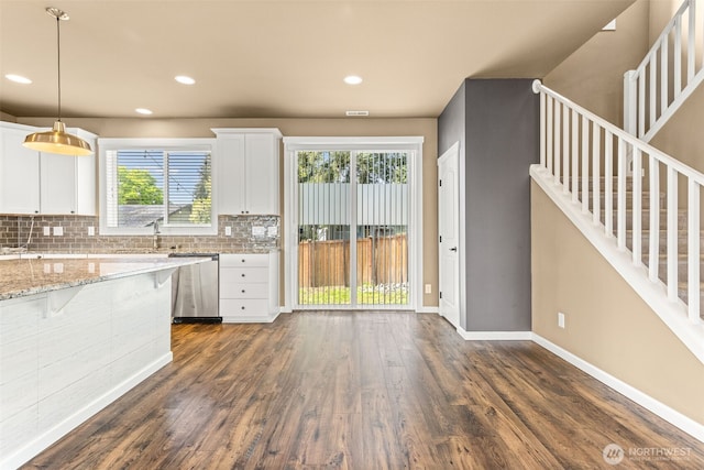 kitchen with decorative backsplash, stainless steel dishwasher, dark wood finished floors, white cabinets, and recessed lighting