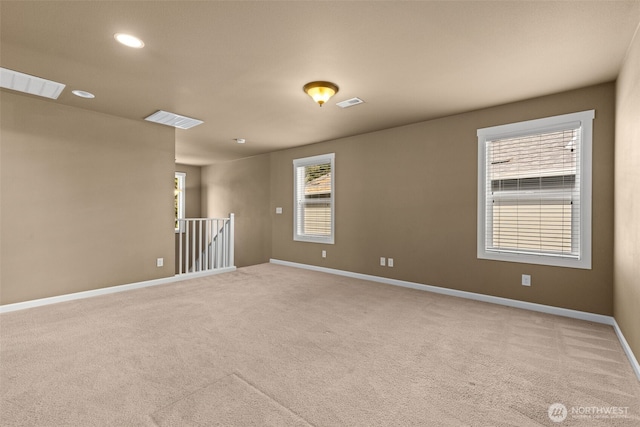 carpeted empty room featuring visible vents, recessed lighting, and baseboards