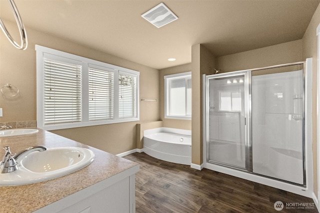 full bathroom with wood finished floors, visible vents, a sink, and a stall shower