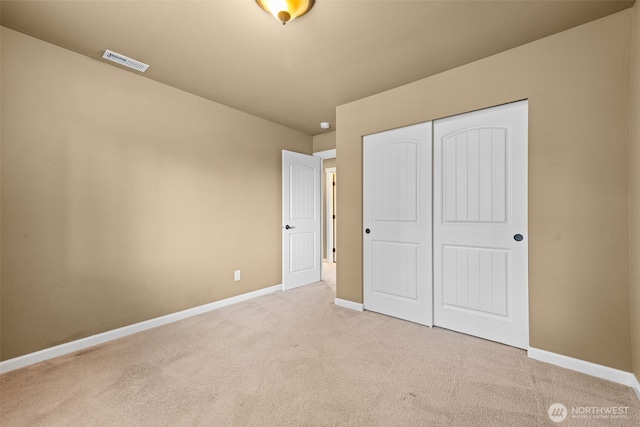 unfurnished bedroom with carpet floors, baseboards, visible vents, and a closet