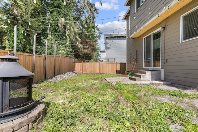 view of yard with a fenced backyard and entry steps