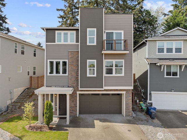 view of front of house with an attached garage, driveway, stairway, and stone siding