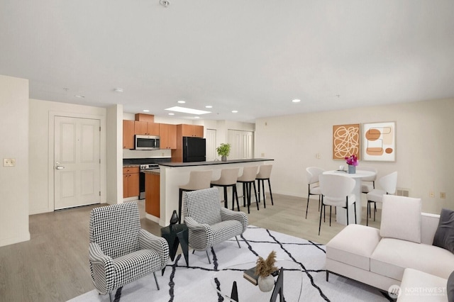 living room featuring light wood-style floors, recessed lighting, and baseboards