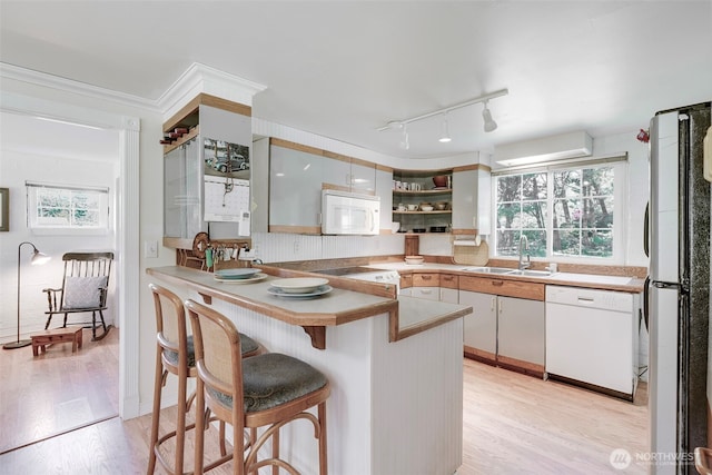 1506 163rd Pl, Long Beach, WA 98631 - kitchen with a sink, open shelves, a kitchen breakfast bar, light wood-type flooring, and white appliances