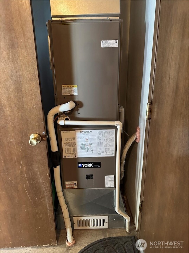 utility room featuring heating unit