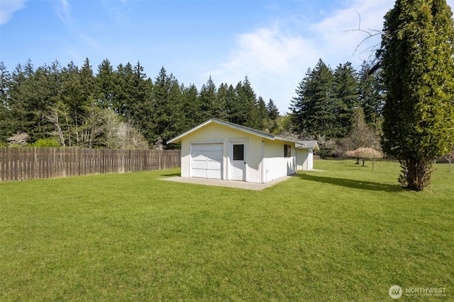 back of property with a lawn, fence, and a garage
