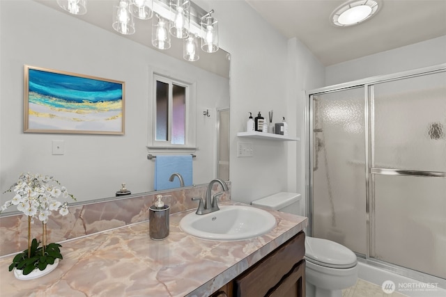 full bath featuring vanity, toilet, and a stall shower