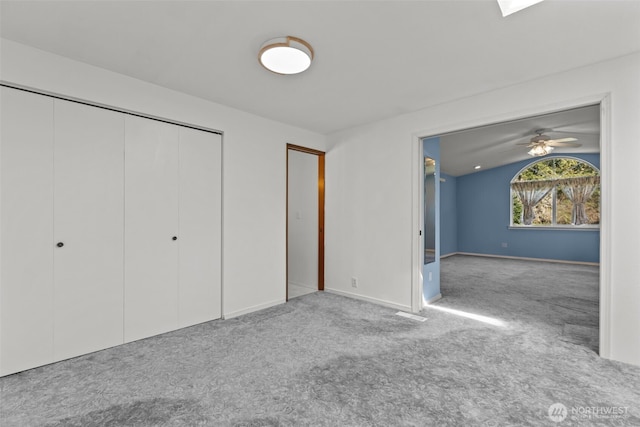 unfurnished bedroom featuring baseboards, carpet, and a closet