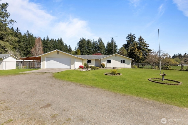 view of front of house with fence, an attached garage, a front lawn, a carport, and driveway