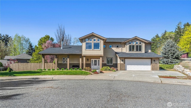 view of front of property with an attached garage, concrete driveway, and fence
