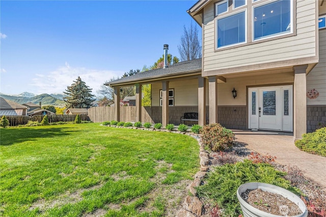 property entrance featuring a yard, fence, and a mountain view