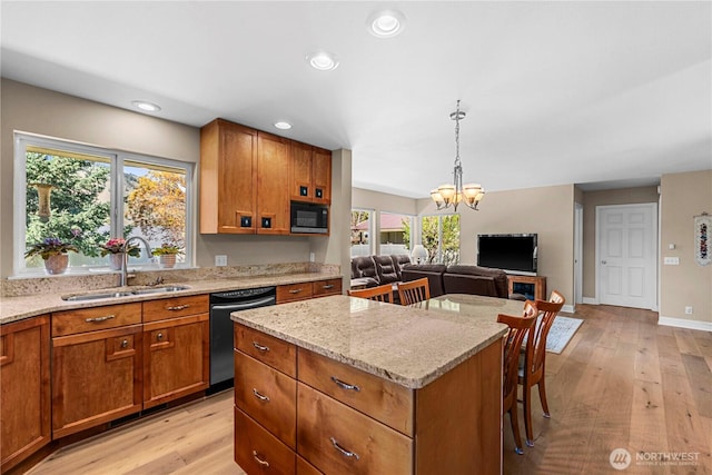 kitchen with dishwasher, a sink, black microwave, light stone countertops, and a notable chandelier