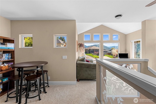 interior space featuring lofted ceiling, carpet flooring, and baseboards
