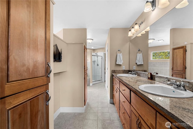 full bath with a shower stall, baseboards, tile patterned floors, and a sink