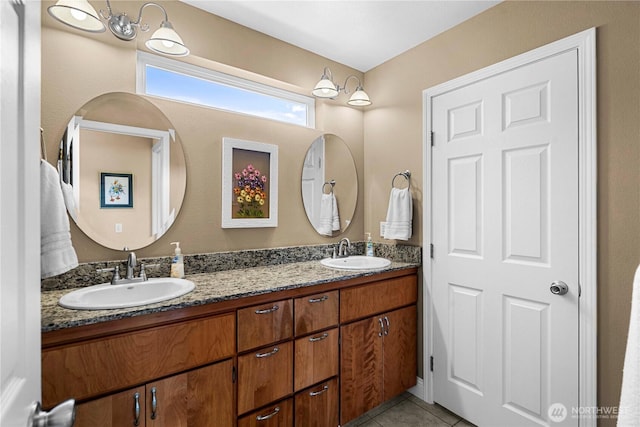 bathroom with tile patterned flooring, a sink, and double vanity