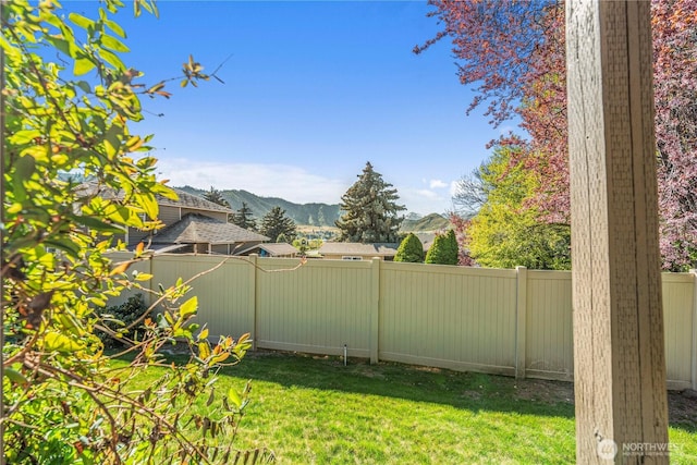 view of yard featuring a fenced backyard and a mountain view