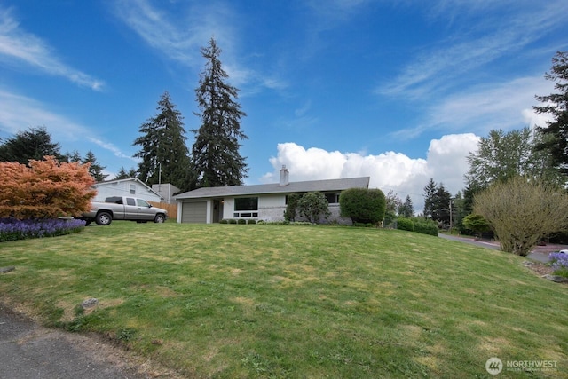 single story home with an attached garage and a front yard