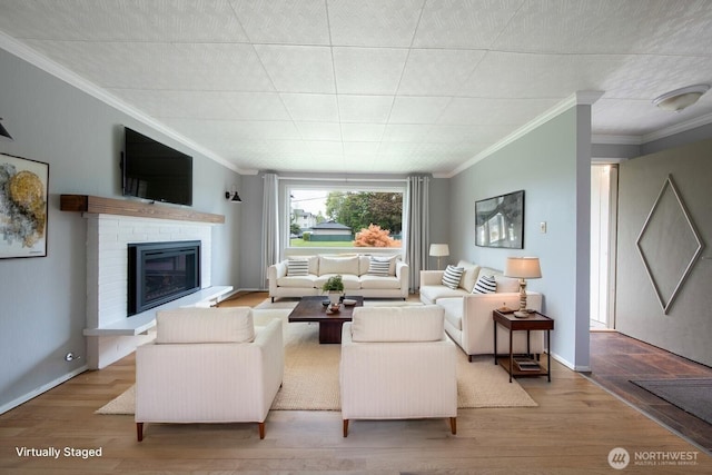 living room with baseboards, ornamental molding, wood finished floors, and a fireplace
