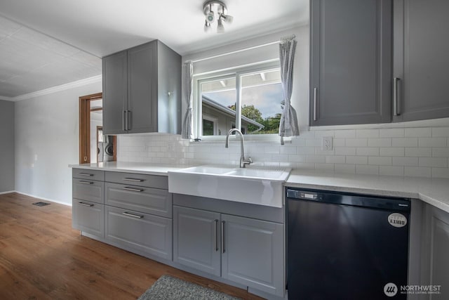 kitchen with decorative backsplash, gray cabinets, crown molding, dishwasher, and a sink