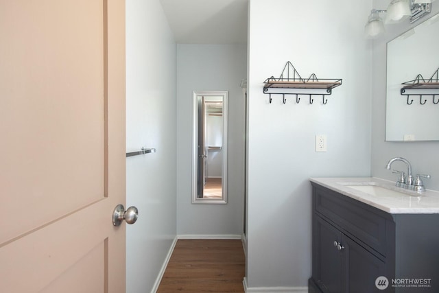 bathroom featuring baseboards, vanity, and wood finished floors