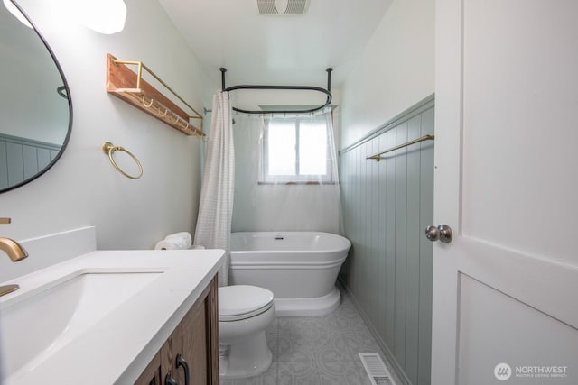 full bath with visible vents, shower / bath combo, toilet, and vanity