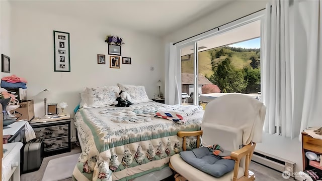 bedroom featuring a baseboard heating unit and access to exterior
