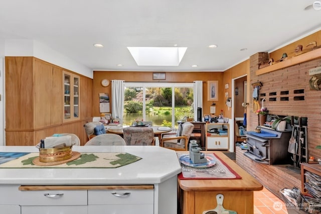 kitchen featuring light countertops, glass insert cabinets, a skylight, and recessed lighting
